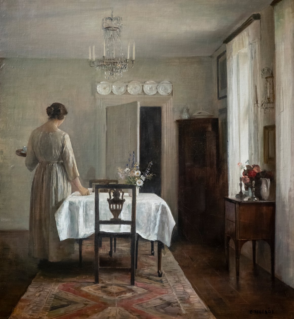 Taiteilijan vaimo kattaa pöytää tekijältä Carl Holsoe