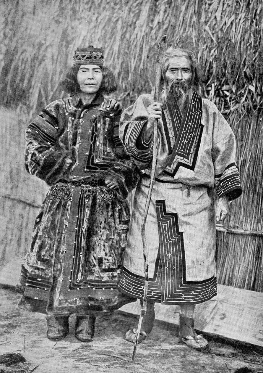 Ainu-pariskunta perinteisen ainu-kodin ulkopuolella, ruokokattoinen kota, 1800-luvun lopulla (bw kuva) tekijältä Messrs. Kajima and Suwo