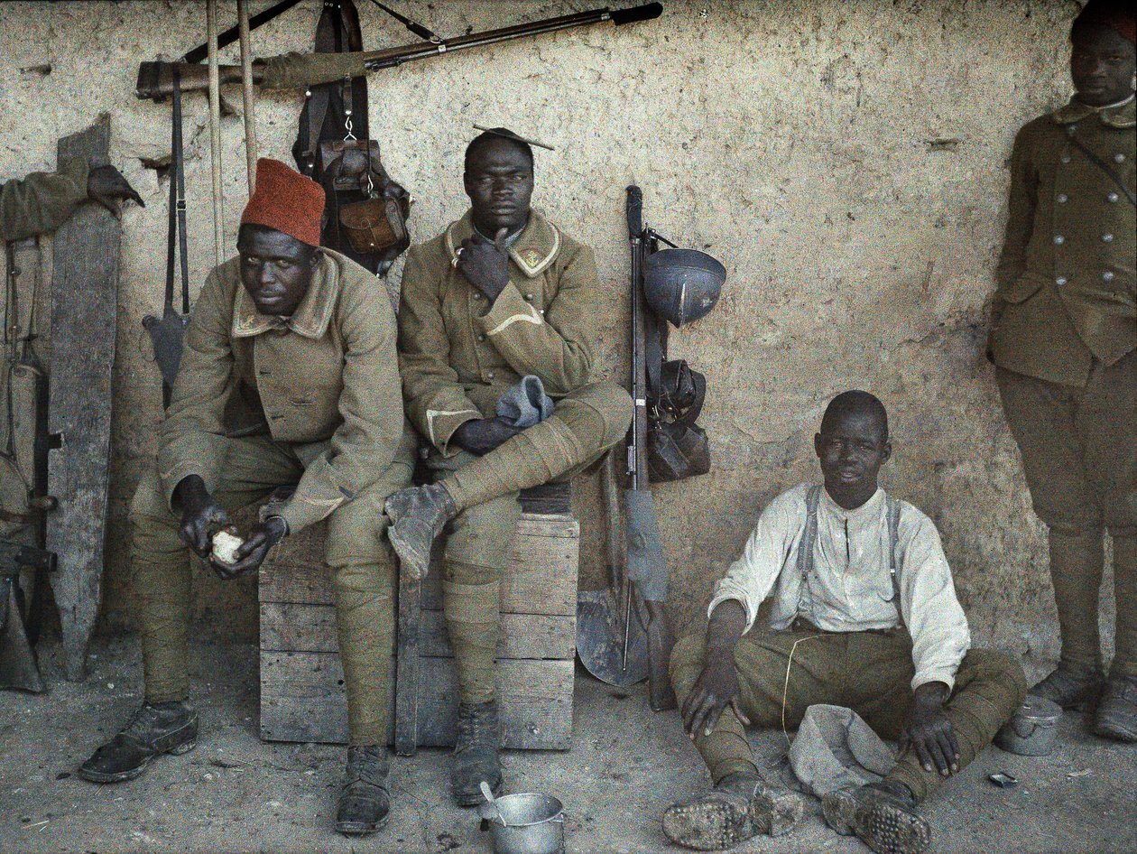 Senegalilaiset sotilaat, jotka palvelevat Ranskan armeijassa jalkasotilaina, jotka lepäävät huoneessa, jossa on aseita ja varusteita, Saint-Ulrich, Departementti Haut-Rhin, Alsace, Ranska, 16. kesäkuuta 1917 (autochrome) tekijältä Paul Castelnau