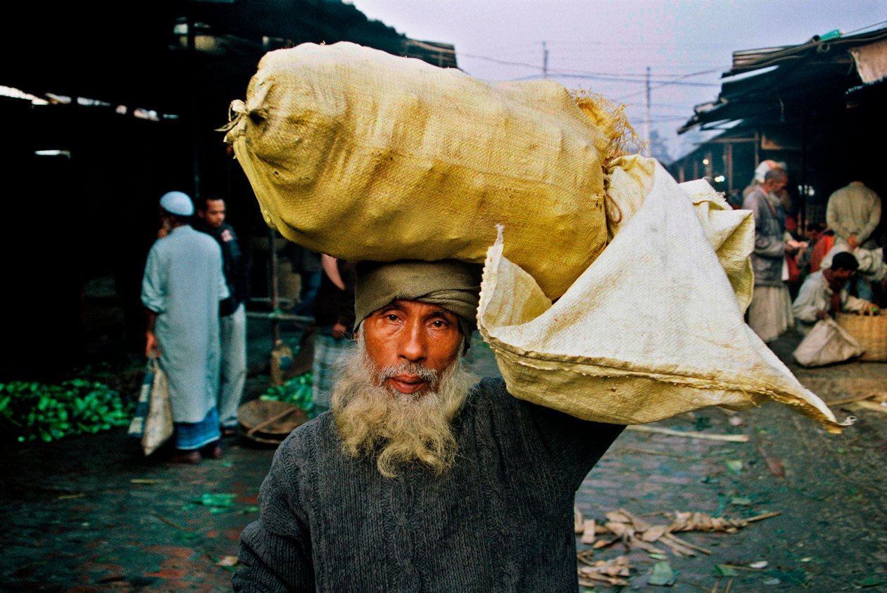 Muotokuva vihannesten myyjästä. Abdus Samad ostaa vihanneksia torilta ja myy niitä kadulla. Nirala kacha basar, Khulna, Bangladesh. tekijältä Unbekannt Unbekannt